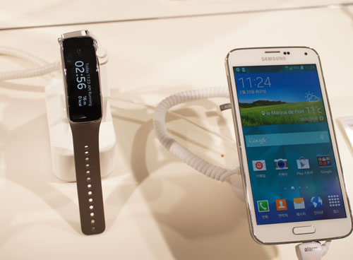Galaxy S5 bên cạnh mẫu đồng hồ thông minh kiêm vòng tay đeo sức khoẻ Galaxy Gear Fit