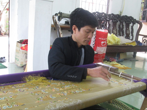Nghệ nhân Vũ Giỏi đang hoàn thiện một trang phục cung đình - Ảnh: Kiều Chinh