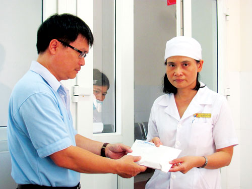 Đại diện Báo Thanh Niên trao tiền cho bác sĩ Nguyễn Thị Thời Loan để bệnh viện lo chi phí điều trị cho bé Y Nôn - Ảnh: Tâm Ngọc