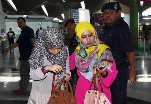 Hai người phụ nữ được cho là thân nhân hành khách trên chuyến bay đang được mời sang khu vực chờ đợi ở sân bay quốc tế Kualar Lumpur