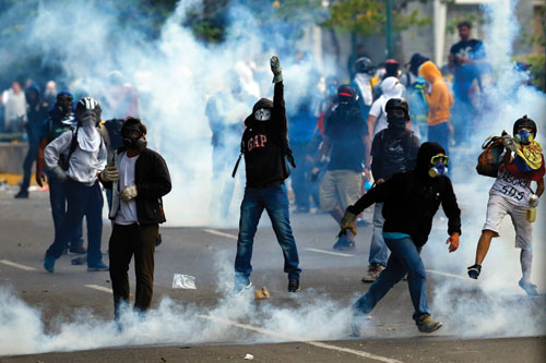Người biểu tình đụng độ với cảnh sát ở thủ đô Caracas của Venezuela -  Ảnh: Reuters