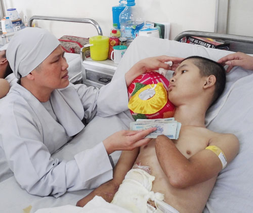 Ni sư Tâm Nguyệt trao tiền cho một bệnh nhân - Ảnh: Thanh Đông