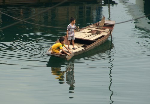 Cậu bé Toàn 6 tuổi chèo thuyền cùng bạn đi chơi 