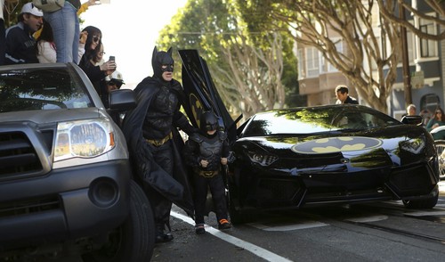 Cậu bé Miles (5 tuổi), bị bệnh máu trắng, ăn mặc như “Batkid” đi cùng với Batman giải cứu một phụ nữ ở San Francisco, California, tháng 11 năm 2013. Em bé này đang được điều trị ung thư khi tham gia vào ngày thực hiện ước mơ của em do tổ chức Make-A-Wish dành cho em - Ảnh: Reuters 