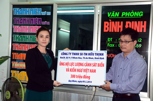 Đại diện Công ty Hữu Thịnh (trái) trao bảng biểu trưng số tiền ủng hộ cho đại diện Báo Thanh Niên - Ảnh: Tâm 