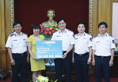 Chị Đặng Thị Phương Thảo trao biểu trưng 200 triệu đồng cho Bộ Tư lệnh cảnh sát biển - Ảnh: Lê Quân