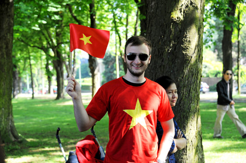 Analoty Peshkov mặc áo đỏ, cầm cờ đỏ sao vàng như những người Việt Nam trong đoàn biểu tình)