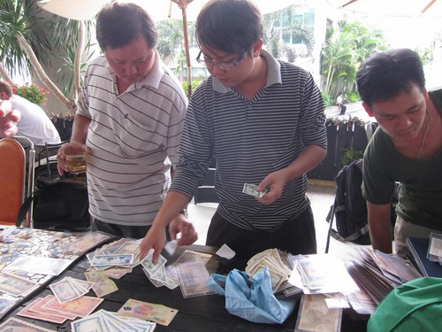 Các thành viên của Hội sưu tầm tiền Tân Phú sắp xếp tiền theo chủ đề về biển đảo Việt Nam