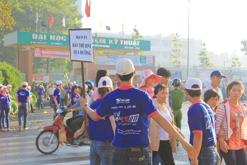 Đội sinh viên tình nguyện dẫn thí sinh qua đường tại Trường ĐH Sư phạm kỹ thuật TP.HCM - Ảnh: Sâm Nguyễn