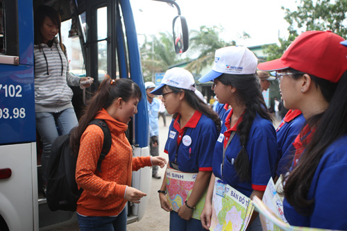 Sinh viên tình nguyện hướng dẫn thí sinh tại Bến xe Miền Đông - Ảnh: Lê Thanh