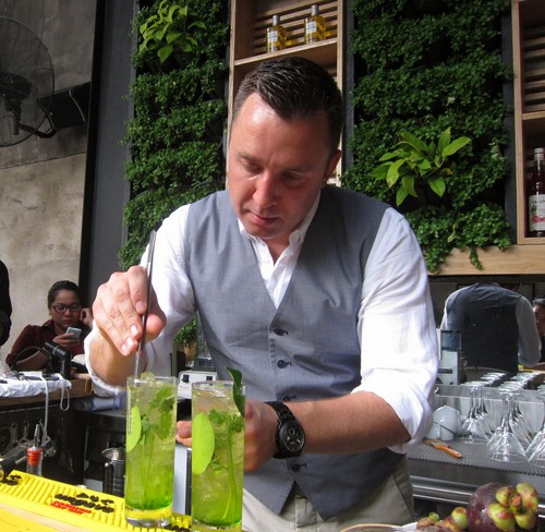Joshua Groom biểu diễn một loại cocktail với lá chanh, ngò, vốn là các loại lá dễ tìm ở chợ Việt Nam - Ảnh: Khải Đơn