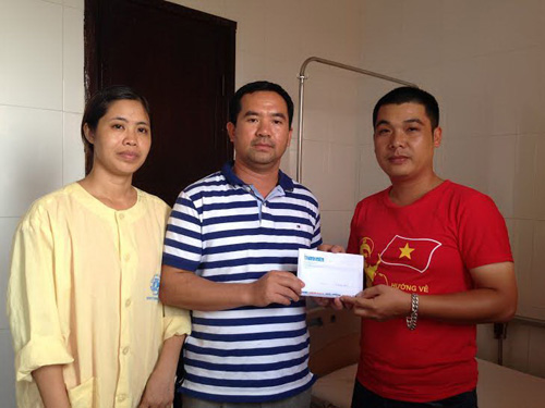 Đại diện Chi đoàn Báo Thanh Niên (bên phải) trao tiền cho anh Lê Minh Phúc -  Ảnh: Thu Trang