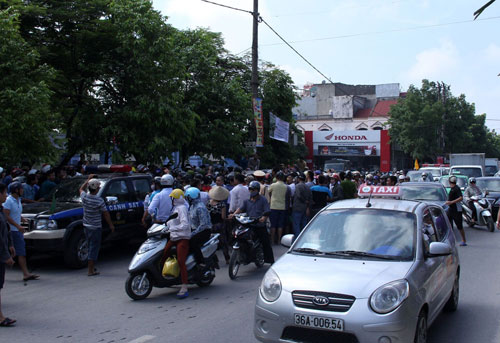 Hiện trường vụ xe ô tô chở phóng viên ANTV bị vây sau khi tài xế va chạm với thanh niên đi xe máy - Ảnh Ái Châu