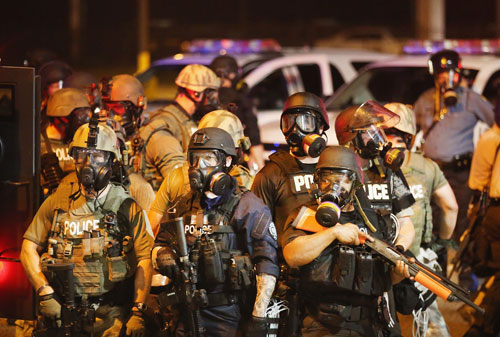 Cảnh sát chống bạo động trên đường phố Ferguson rạng sáng 18.8 - Ảnh: AFP