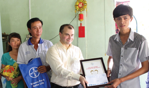 Đại diện Bayer Việt Nam trao quà và chúc mừng em Nguyễn Khánh Duy, tân sinh viên Khoa Báo chí, ĐH Cần Thơ - Ảnh: B.Hằng