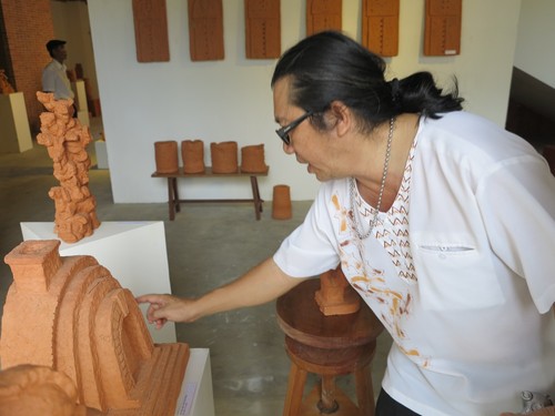 Nghệ sĩ Đoàn Xuân Hùng bên tác phẩm tạo nên một lò gốm của người làng gốm Thanh Hà, và dùng vân tay của họ chạm lên tác phẩm