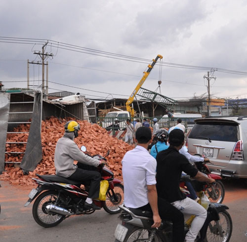 Xe tải bẻ lái, 2 thanh niên thoát chết, hàng chục tấn gạch đổ ra đường