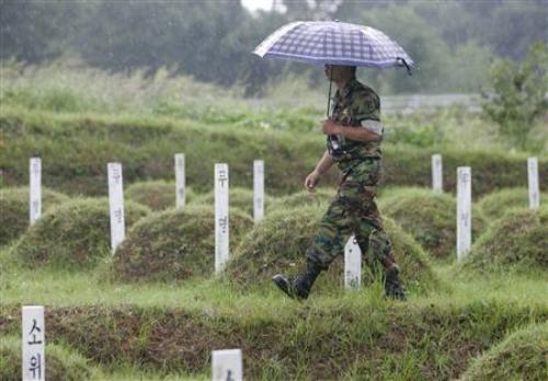 Một binh sĩ Hàn Quốc đi ngang những ngôi mộ của các binh sĩnh Triều Tiên và Trung Quốc tại Nghĩa trang Quân thù, gần khu phi quân sự chia cắt hai miền Triều Tiên ở Paju, cách thủ đô Seoul (Hàn Quốc) 52 km về phía bắc - Ảnh: Reuters