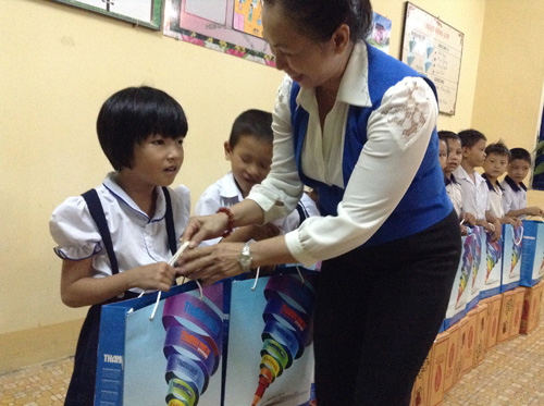 Cô Nguyễn Thị Lợi, Hiệu trưởng Trường tiểu học Huỳnh Minh Thạnh, trao quà trung thu cho các học sinh 