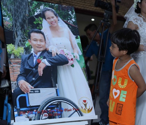  Cô bé Nguyễn Xuân Quỳnh (5 tuổi, ngụ ở tỉnh Đồng Tháp) tò mò ngắm hình đám cưới của cha mẹ