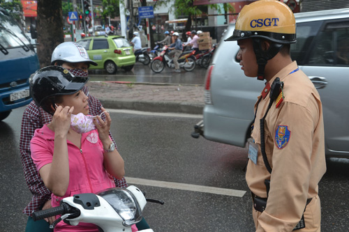 Cảnh sát giao thông nhắc nhở người đi đường đội mũ bảo hiểm đúng cách - Ảnh: Nguyễn Tuấn 