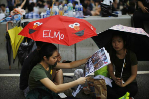 Người biểu tình ngồi tại đường phố theo dõi tin tức - Ảnh: AFP