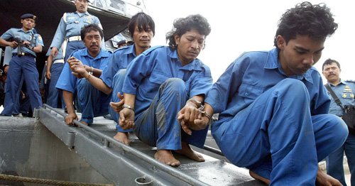 Những tên cướp biển bị lực lượng an ninh Indonesia bắt giữ  - Ảnh: Reuters