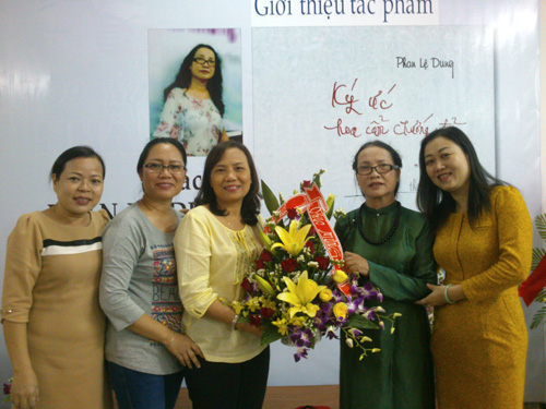 Nhà thơ Phan Lệ Dung (thứ hai từ phải qua) nhận hoa chúc mừng của bạn bè -  Ảnh: B.N.L