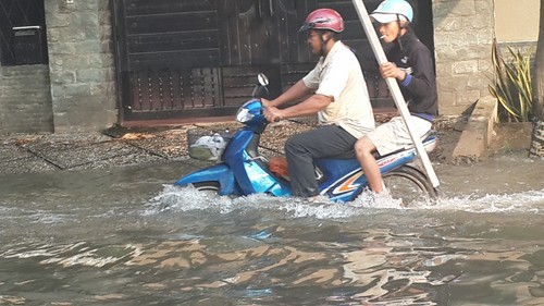 Cột mốc cảnh báo triều cường nằm bên trong bờ tường bao ngăn triều. Bên ngoài là sông Sài Gòn, nước đang dâng rất cao