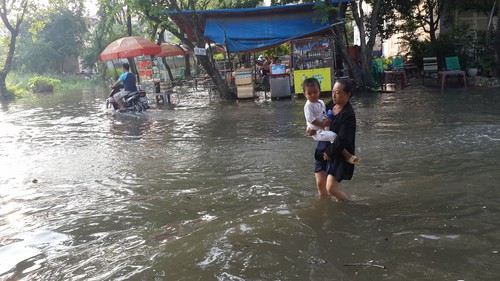 Cột mốc cảnh báo triều cường nằm bên trong bờ tường bao ngăn triều. Bên ngoài là sông Sài Gòn, nước đang dâng rất cao 3