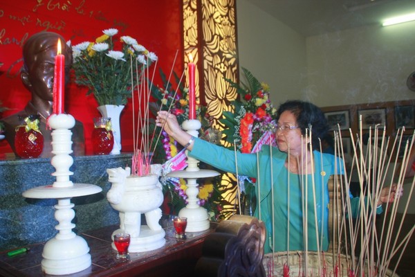 Bà Phan Thị Quyên thắp hương lên bàn thờ chồng