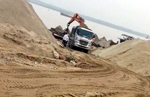 Một chiếc xe tải  đã cơi nới thùng xe đang “ăn cát” chuẩn bị phi ra đường