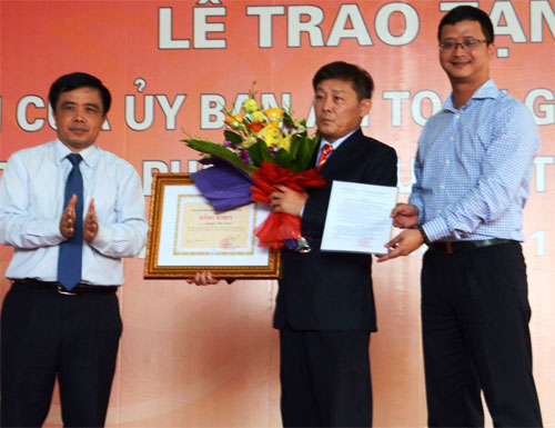 Phó Chủ tịch UBND tỉnh Nghệ An Huỳnh Thanh Điền (bìa trái) trao bằng khen cho ông Định - Ảnh: Hòa Phạm