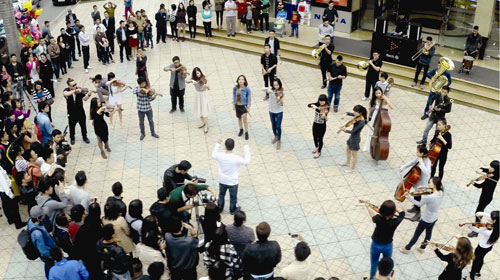 Các nghệ sĩ trẻ của dàn nhạc Rhapsody Philharmonic biểu diễn ngẫu hứng tại góc trung tâm thương mại Vincom - Ảnh: TL