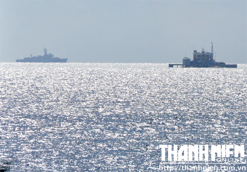 Tàu hộ vệ tên lửa của Trung Quốc (bên trái) rình rập gần đảo Cô Lin (bên phải). Hình chụp từ nóc buồng hành trình tàu HQ-012 Lý Thái Tổ