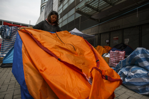 Một người biểu tình đang thu dọn lều của mình - Ảnh: Reuters