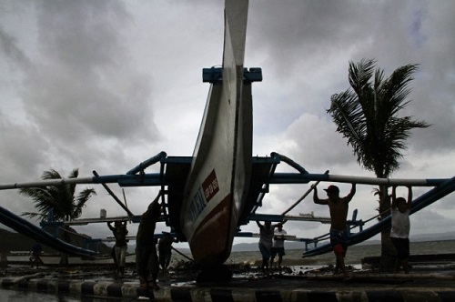 Ngư dân Philippines di chuyển tàu cá lên khu vực cao hơn, tránh mực nước biển dâng do bão Hagupit.