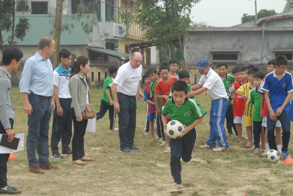 Đại sứ Stephen Mcmahon, cựu cầu thủ bóng đá Anh (áo trắng) giao lưu với các em học sinh Phú Bài - Ảnh: Ngọc Thạnh