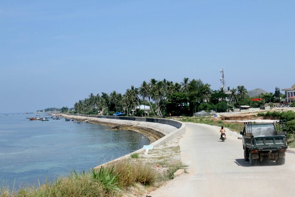 Con đường dẫn vào trung tâm huyện đảo được trải bê tông với một bên là biển và một bên là những hàng dừa xanh