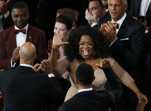 Nữ hoàng truyền hình Ophra Winfrey giơ tay chúc mừng các thành viên của phim Selma sau khi ca khúc Glory của phim giành được giải Ca khúc trong phim xuất sắc nhất