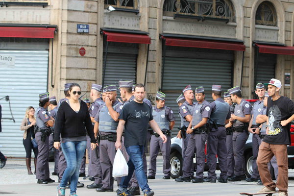 Khách bộ hành đi qua một nơi dày đặc cảnh sát bên cầu vượt Viatudo do Chá ở trung tâm thành phố