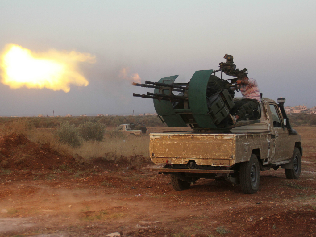 Lực lượng nổi dậy xả súng máy chống quân chính phủ ở Syria - Ảnh: AFP