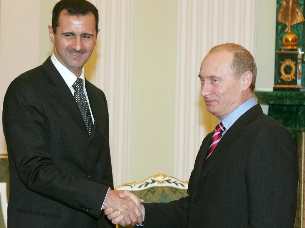 Tổng thống Syria Bashar al-Assad và Tổng thống Nga Vladimir Putin bắt tay trong một cuộc gặp tại điện Kremlin năm 2006 - Ảnh: Reuters