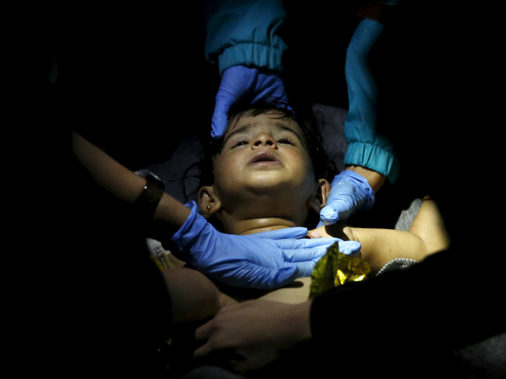 Các bác sĩ cố cứu sống bé trai sau vụ chìm thuyền - Ảnh: Reuters