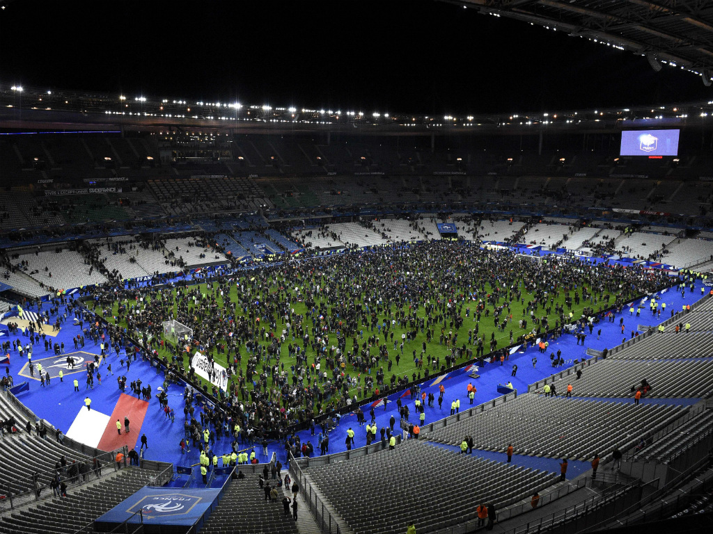 Khán giả tràn xuống sân để sơ tán sau vụ nổ bom gần sân vận động Stade de France đêm 13.11 - Ảnh: AFP