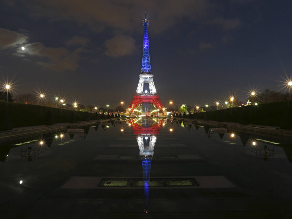 Tháp Eiffel được thắp đèn theo màu cờ Pháp - Ảnh: Reuters