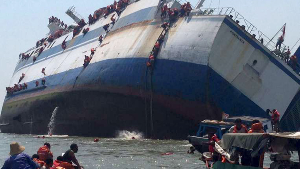 Hành khách thoát ra từ chiếc phà KM Wihan Sejahtera bị đắm ở cảng Tanjung Perak (Indonesia) ngày 16.11.2015 - Ảnh: Reuters