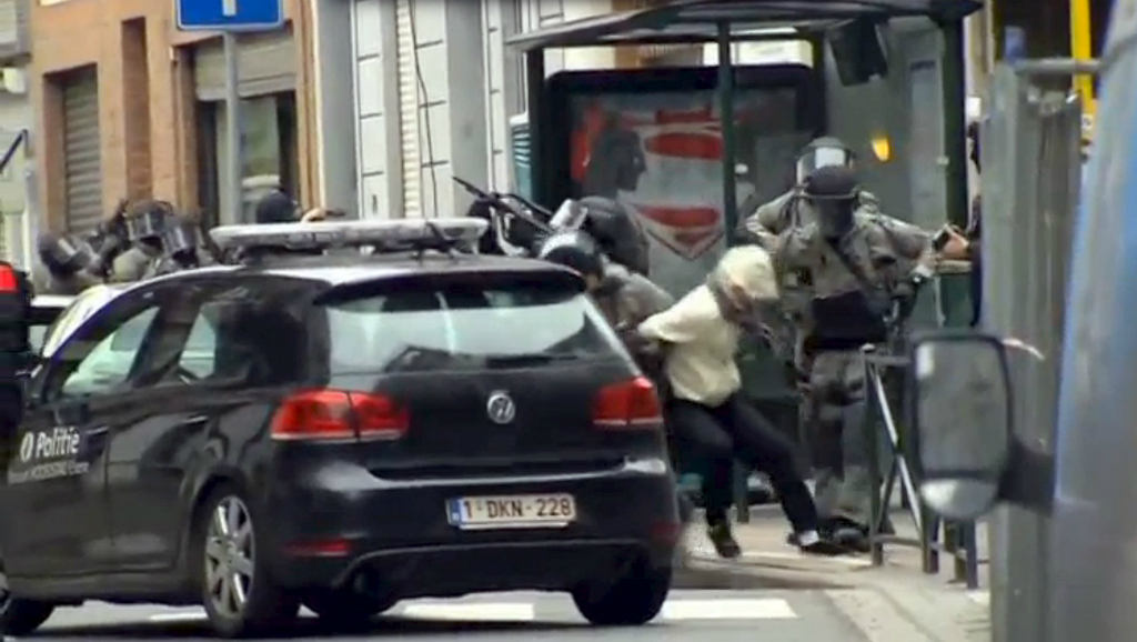Lực lượng an ninh Bỉ khống chế một nghi phạm trong cuộc đột kích ngày 18.3 tại vùng ngoại ô Molenbeek, gần thủ đô Brussels - Ảnh: Reuters