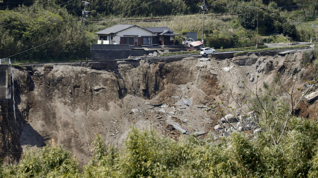 Động đất khiến con đường ở Kumamoto bị sụp xuống, xe hơi treo lơ lửng - Ảnh: Reuters