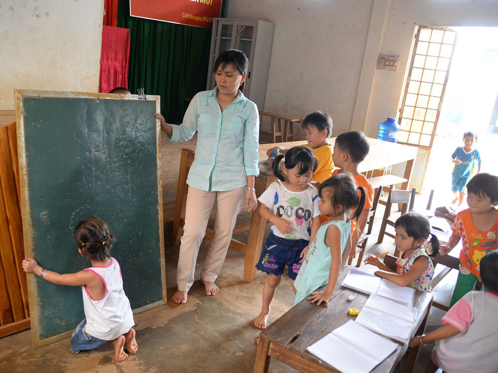 Cô - trò trong lớp học tạm bợ ở hội trường thôn Cây Da - Ảnh: Lam Như